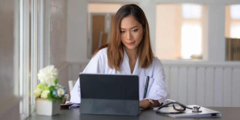 Imagem que representa uma enfermeira explorando em seu computador as vagas disponíveis no site da Unimed Rio Preto.