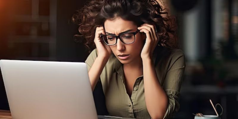 Imagem que representa uma candidata tensa na frente do seu computador esperando o resultado do processo seletivo.